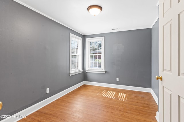 empty room with hardwood / wood-style floors and ornamental molding