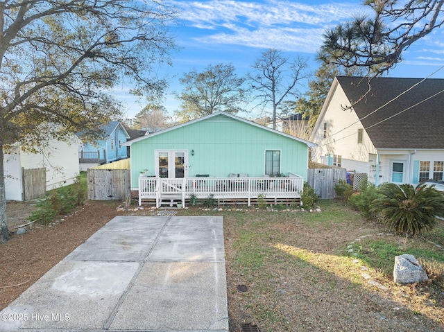 rear view of house with a wooden deck and a patio area