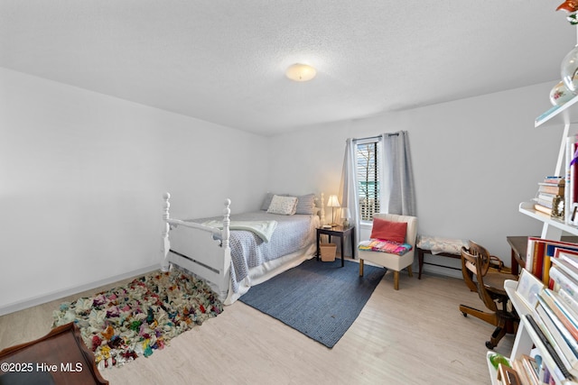 bedroom featuring light hardwood / wood-style floors and a textured ceiling