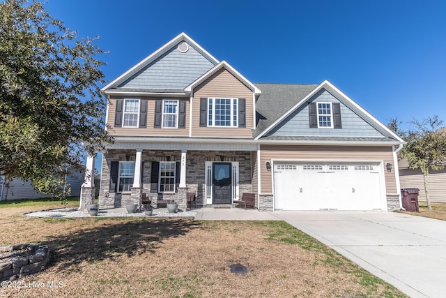 craftsman-style home featuring a garage, a front yard, and covered porch