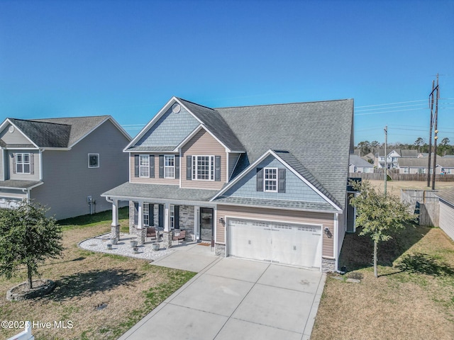 craftsman inspired home featuring a garage, a porch, and a front lawn