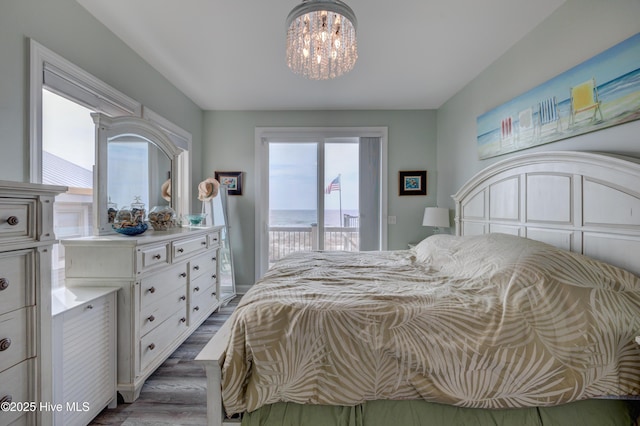 2017 W Beach Dr, Oak Island, NC 28465 - bedroom with access to exterior, a chandelier, and dark wood-type flooring