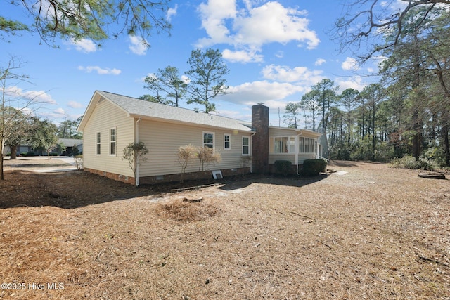 rear view of property featuring crawl space and a chimney