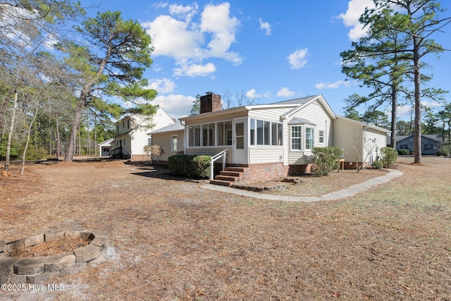 view of front facade with a chimney and a sunroom