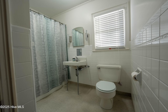 bathroom with toilet, sink, a shower with curtain, crown molding, and tile walls