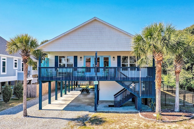 rear view of property with driveway, stairway, fence, a porch, and a carport