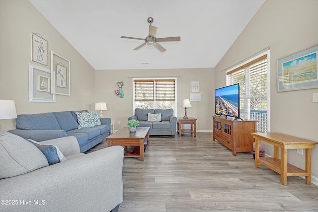 living room featuring a wealth of natural light, lofted ceiling, light wood-type flooring, and a ceiling fan