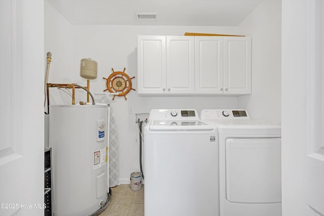 washroom with light tile patterned floors, water heater, cabinet space, visible vents, and independent washer and dryer