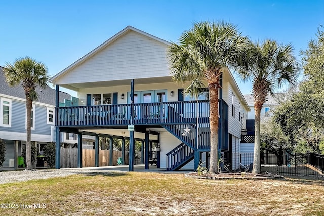 rear view of property featuring a porch, fence, stairs, driveway, and a carport