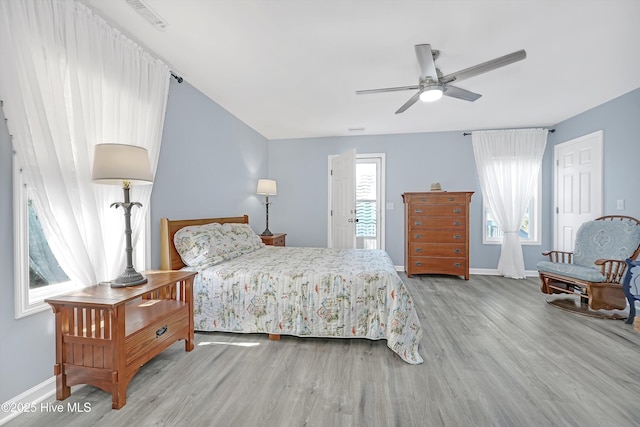 bedroom featuring a ceiling fan, baseboards, and wood finished floors