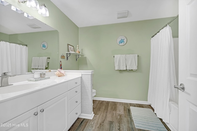 full bath featuring curtained shower, toilet, wood finished floors, vanity, and baseboards