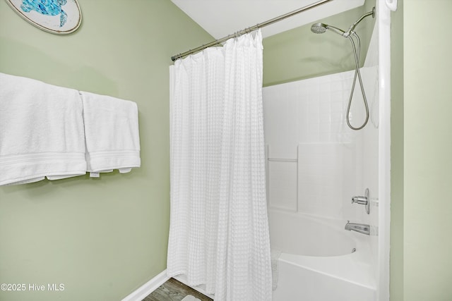 full bath featuring shower / tub combo and baseboards