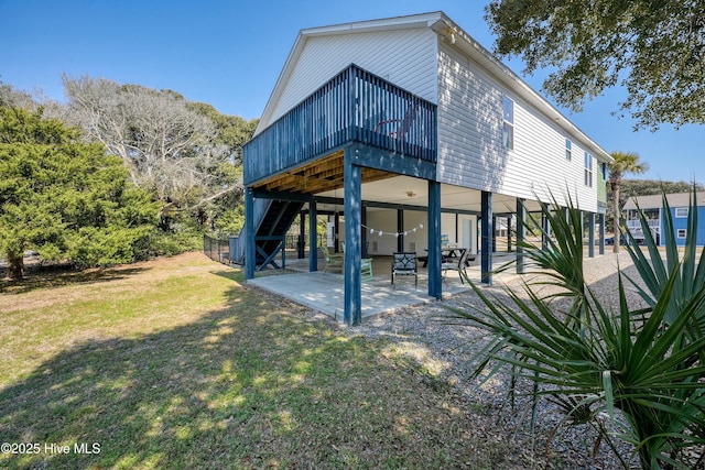 back of property featuring a patio area, a lawn, and stairs