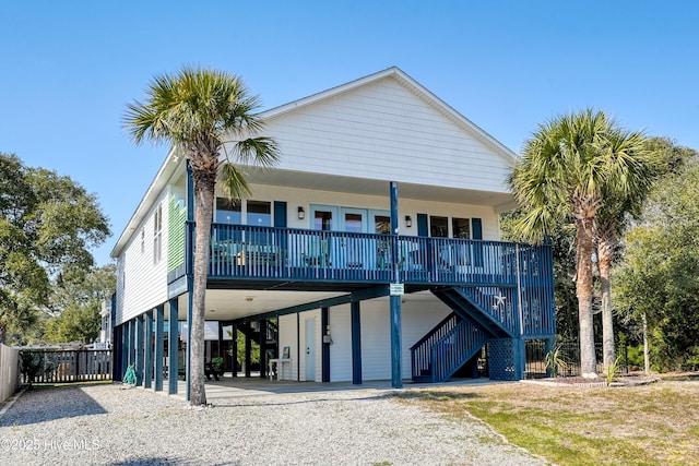 view of front of home featuring a carport, covered porch, driveway, and stairway