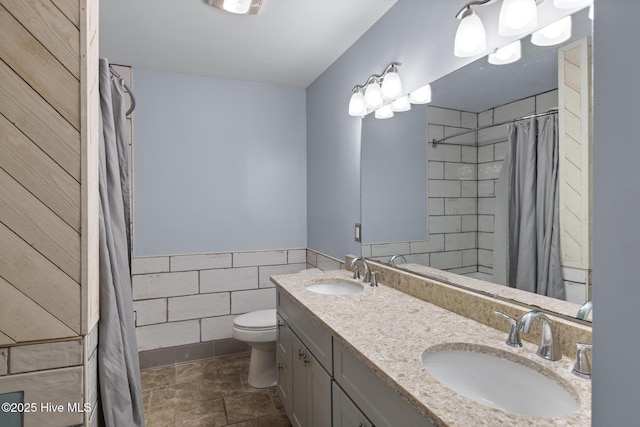 bathroom featuring tile walls, vanity, toilet, and a shower with shower curtain