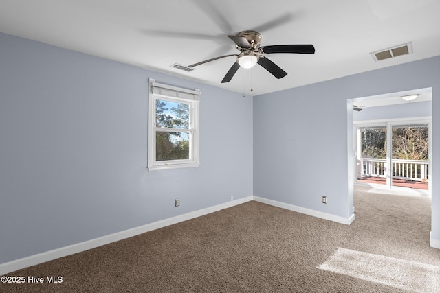 empty room with ceiling fan, plenty of natural light, and carpet