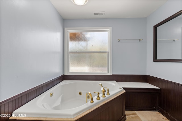 bathroom featuring a washtub and wooden walls