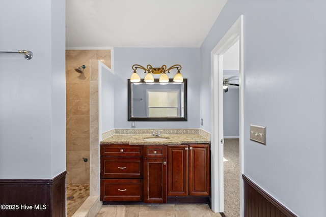 bathroom featuring a tile shower and vanity