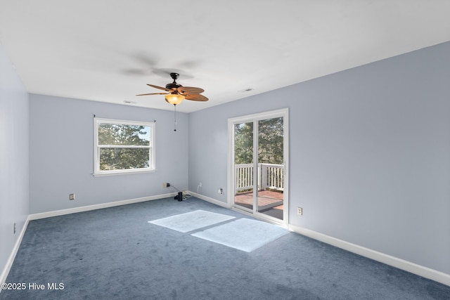 unfurnished room featuring ceiling fan, dark colored carpet, and a healthy amount of sunlight