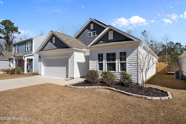 view of front of house with a garage, central AC unit, and a front yard