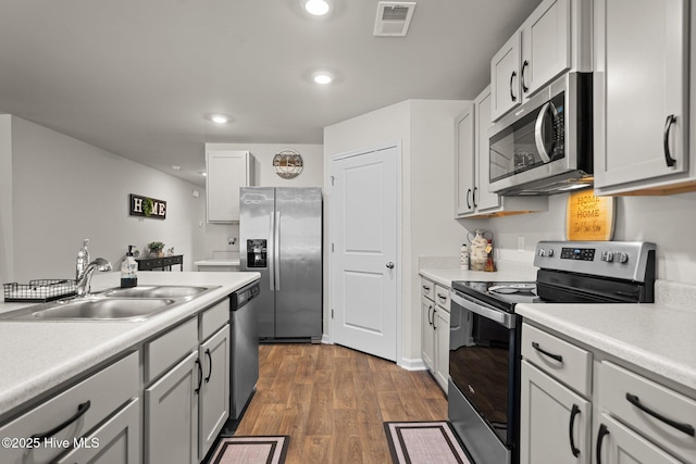 kitchen with sink, stainless steel appliances, and dark hardwood / wood-style floors