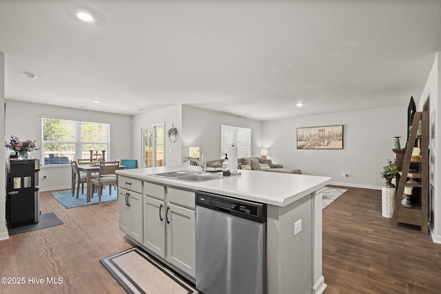 kitchen with dark hardwood / wood-style floors, white cabinetry, dishwasher, sink, and an island with sink