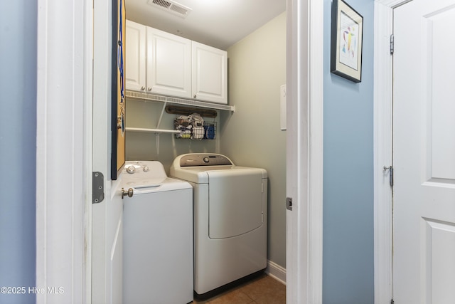 washroom featuring cabinets, independent washer and dryer, and dark tile patterned floors