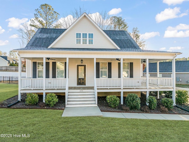 view of front of house with a porch, ceiling fan, a front yard, and a shingled roof