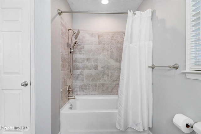 bathroom featuring shower / bath combination with curtain and a textured ceiling