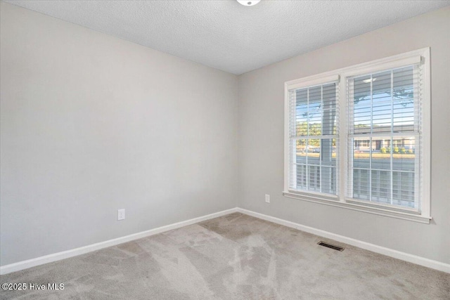 carpeted spare room featuring a textured ceiling