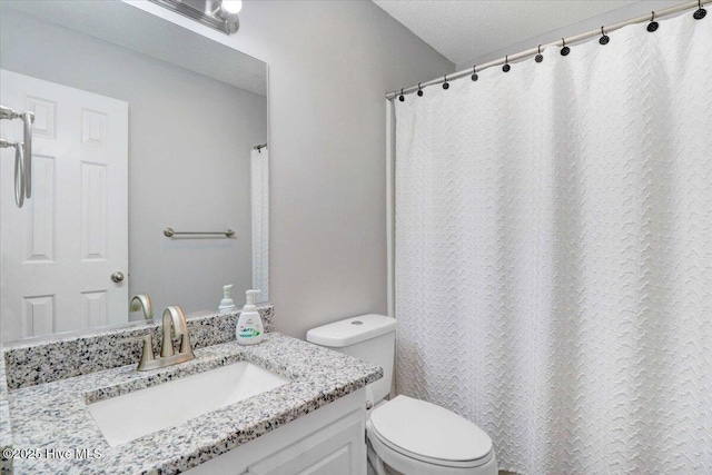 bathroom featuring vanity, a textured ceiling, and toilet