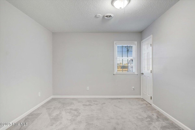 carpeted spare room with a textured ceiling