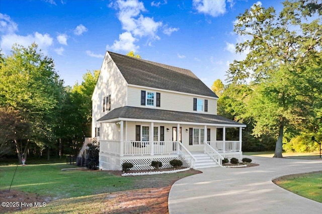 country-style home featuring covered porch and a front yard