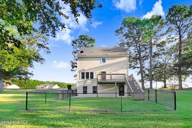 rear view of property featuring a wooden deck and a lawn