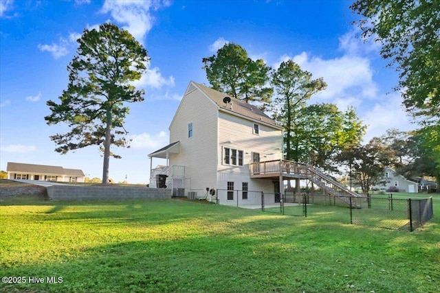 back of property with a deck and a lawn