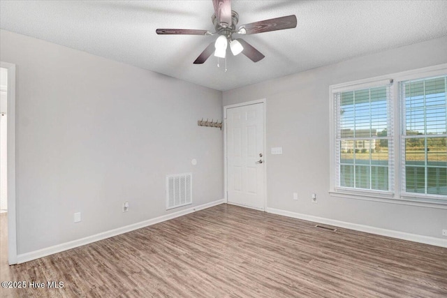 spare room featuring hardwood / wood-style flooring, ceiling fan, and a textured ceiling