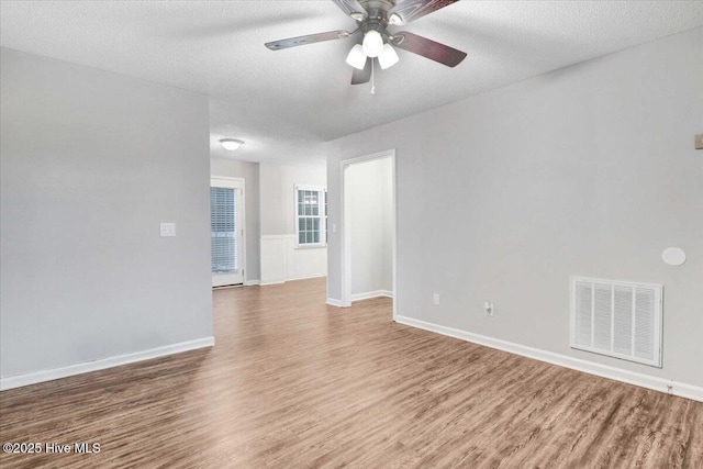 unfurnished room with wood-type flooring, ceiling fan, and a textured ceiling