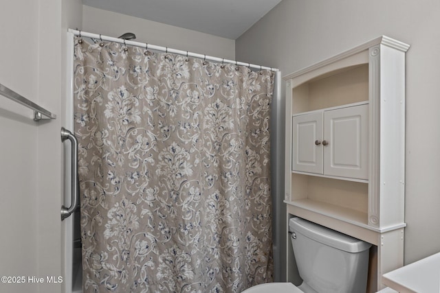 bathroom featuring a shower with shower curtain and toilet