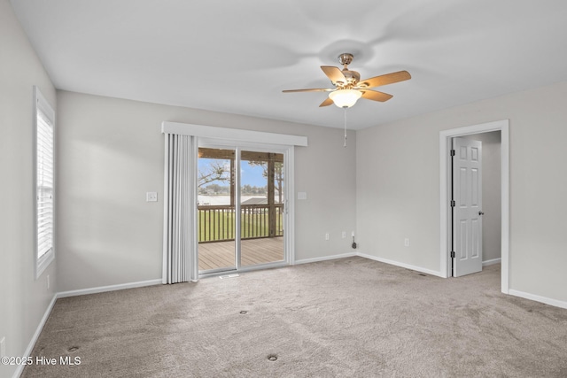 carpeted spare room featuring ceiling fan and baseboards