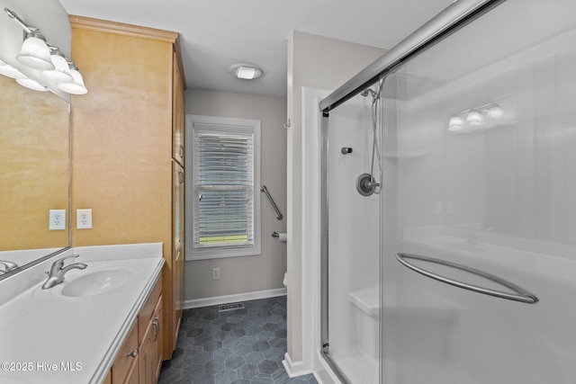 bathroom with vanity, visible vents, a stall shower, baseboards, and toilet