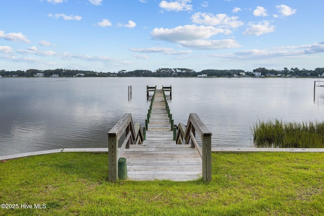 view of dock featuring a water view and a yard