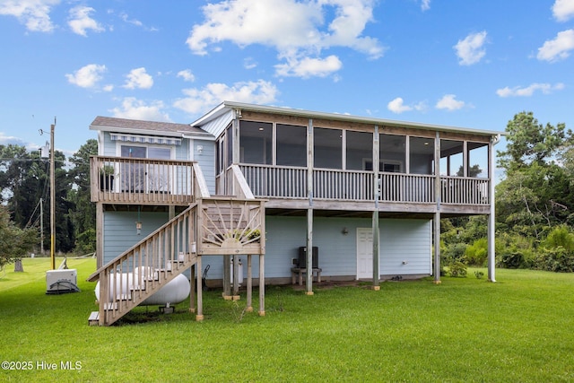 rear view of property with stairs, a sunroom, and a yard