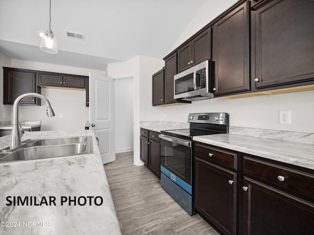 165 Vista Cay Dr, Hubert, NC 28539 - kitchen with decorative light fixtures, sink, dark brown cabinetry, stainless steel appliances, and light wood-type flooring