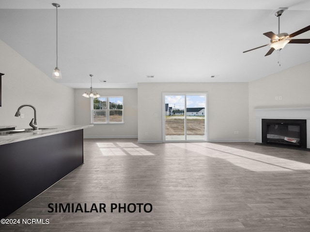 165 Vista Cay Dr, Hubert, NC 28539 - unfurnished living room with ceiling fan with notable chandelier, vaulted ceiling, light hardwood / wood-style floors, and sink