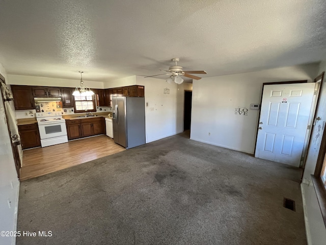 kitchen featuring pendant lighting, sink, white range with electric stovetop, stainless steel fridge with ice dispenser, and light colored carpet