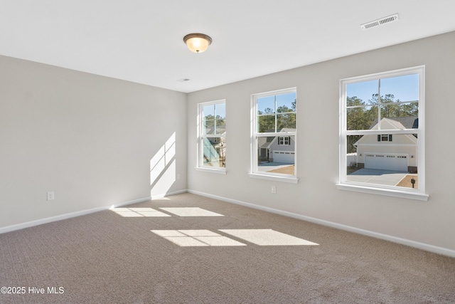 carpeted empty room featuring visible vents and baseboards