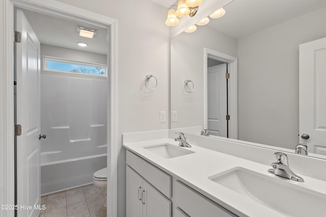 bathroom with double vanity, a sink, toilet, and tile patterned floors