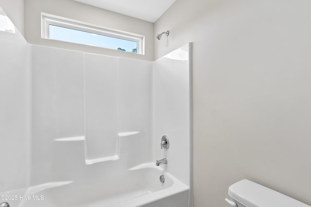 bathroom with shower / washtub combination and toilet