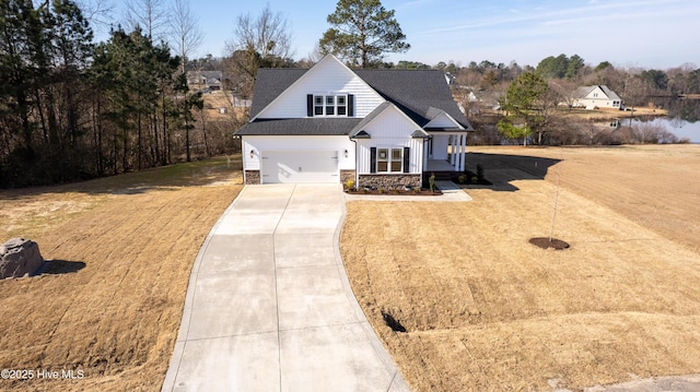 modern farmhouse style home with concrete driveway, a front lawn, roof with shingles, and an attached garage