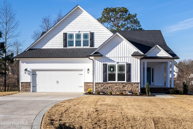 view of front of property featuring roof with shingles, a porch, concrete driveway, a garage, and a front lawn